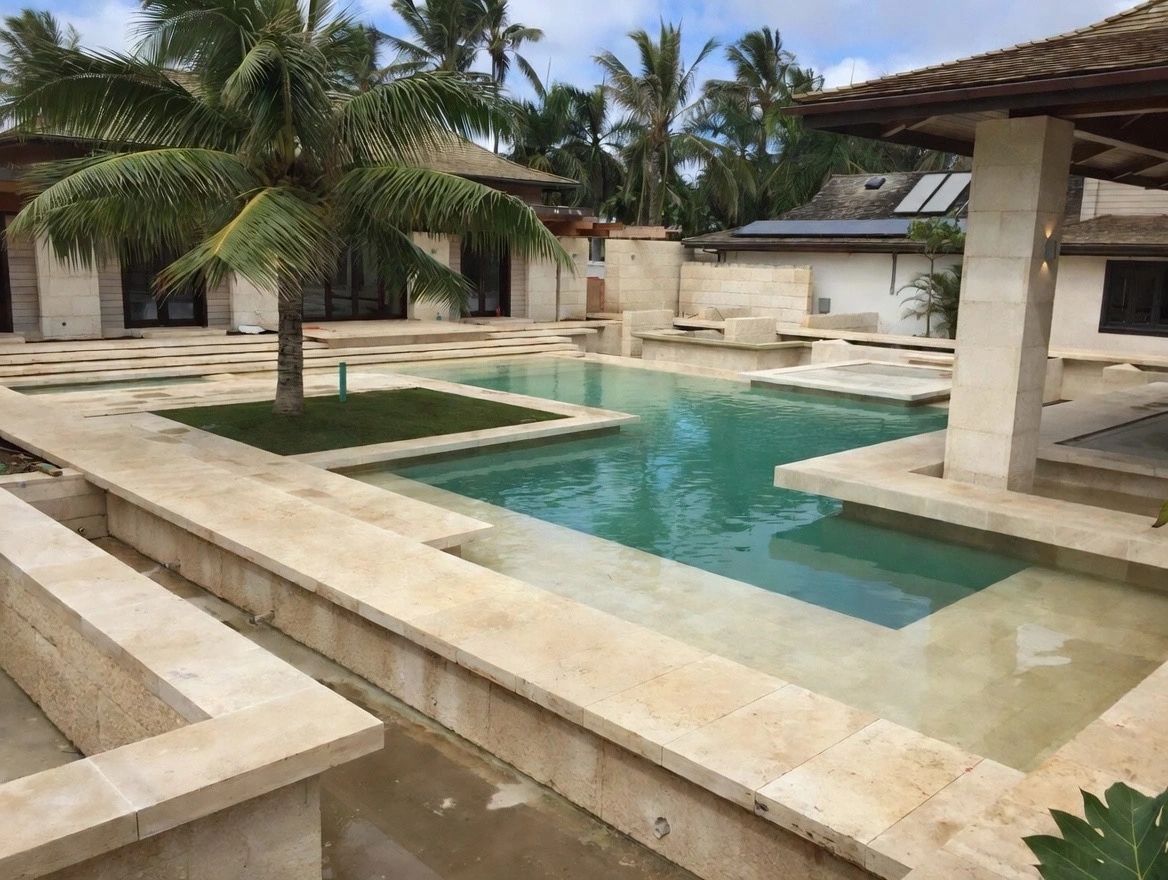 Travertine pool courtyard framed by palms