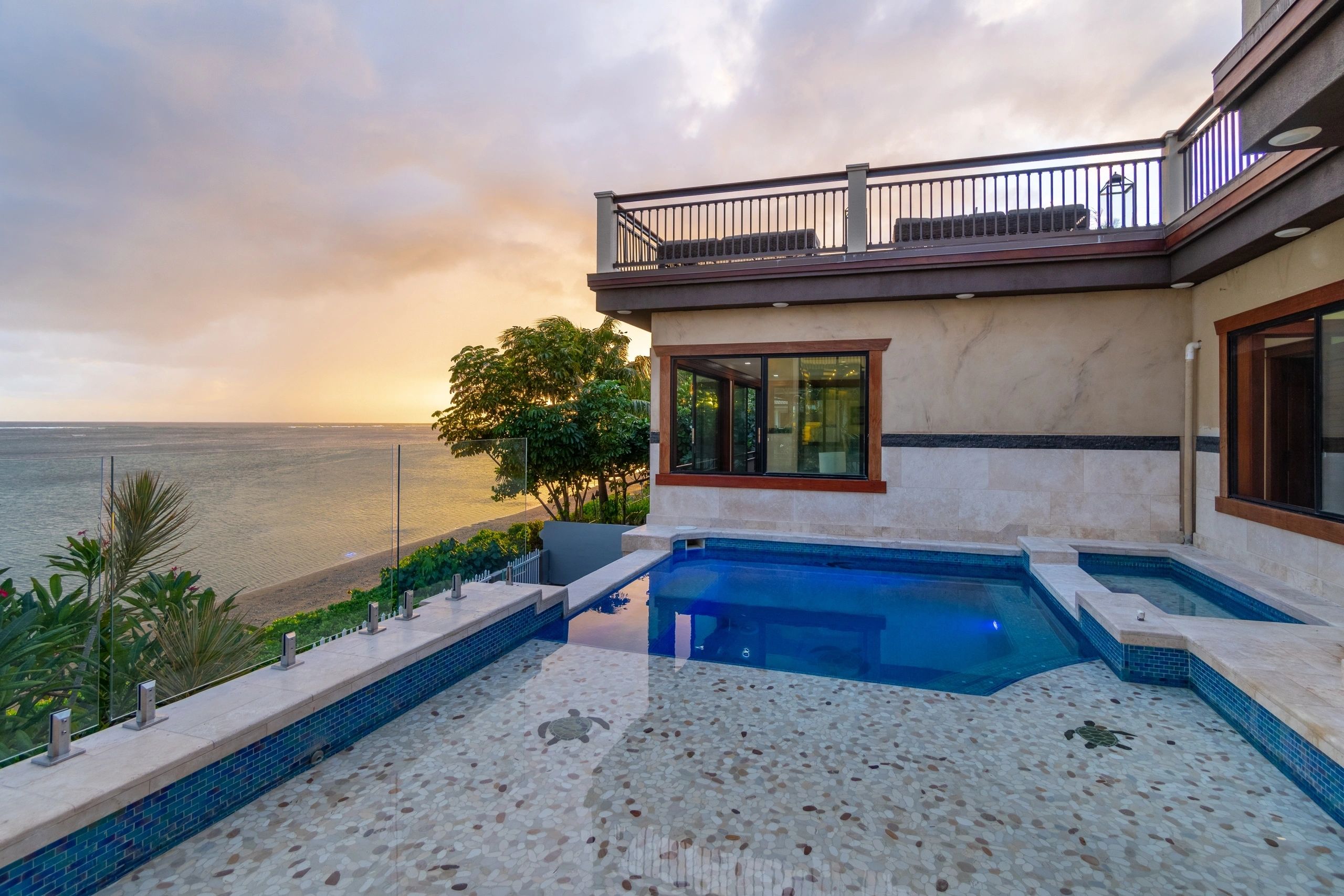 Pool with turtle mosaic overlooking the ocean at sunset